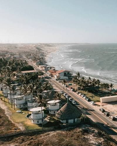 Vista aérea da orla de Emboaca com a estrada paralela à praia, dunas e turbinas de vento ao fundo
